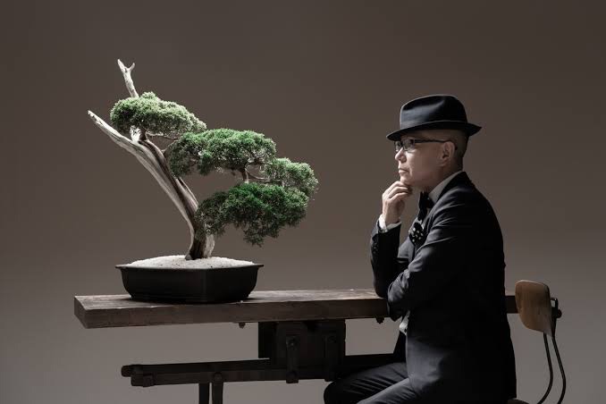 石原和幸氏が盆栽を静かに眺めている様子